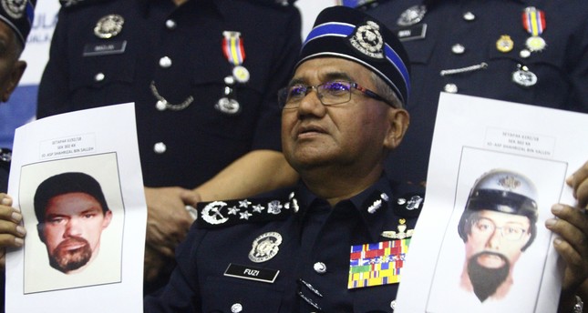 الشرطة الماليزية مع صور المشتبه بهم 